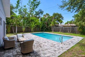 A backyard with a swimming pool, wicker furniture, and a wooden fence. - Sleeps 8 Private Pool Dog Friendly Balcony (Sarasota)
