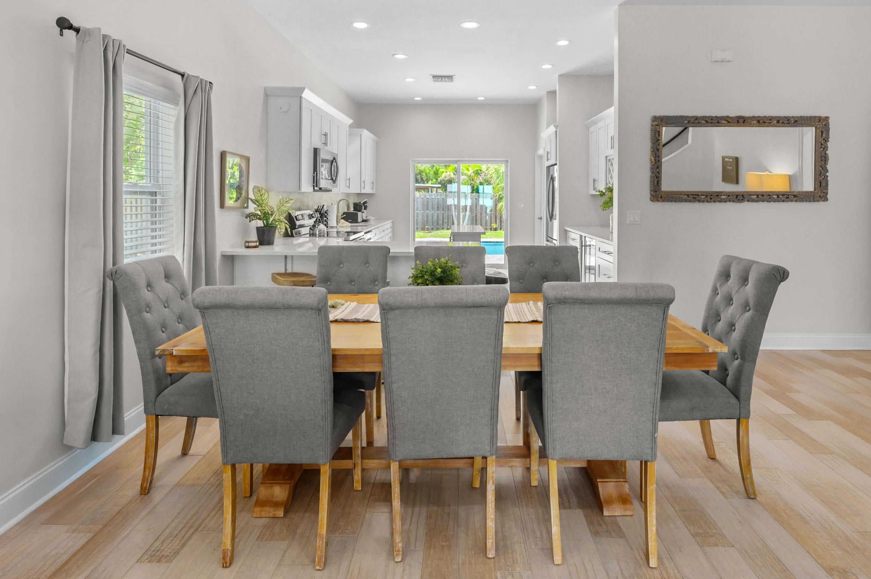 A dining area with a wooden table and grey upholstered chairs.