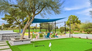 A well-maintained golf course with a putting green, a tee box, and a seating area with chairs. - Fun-filled Oasis Pool Pickleball Games Galore (Scottsdale)
