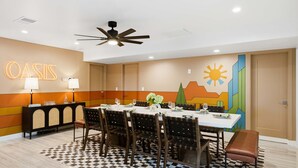 A conference room with a table set for a meeting, a ceiling fan, and a wall with a 'OASIS' sign. - Fun-filled Oasis Pool Pickleball Games Galore (Scottsdale)