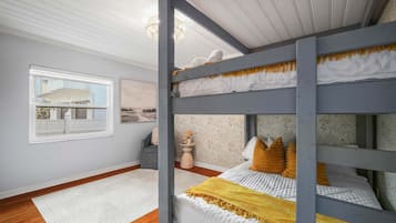 A room with a bunk bed, a window with a view, a rug, and a chair.