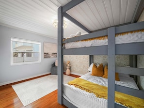 A room with a bunk bed, a window with a view, a rug, and a chair. - Luxe Lakefront w Pool Pickleball Private Dock (Sebring)