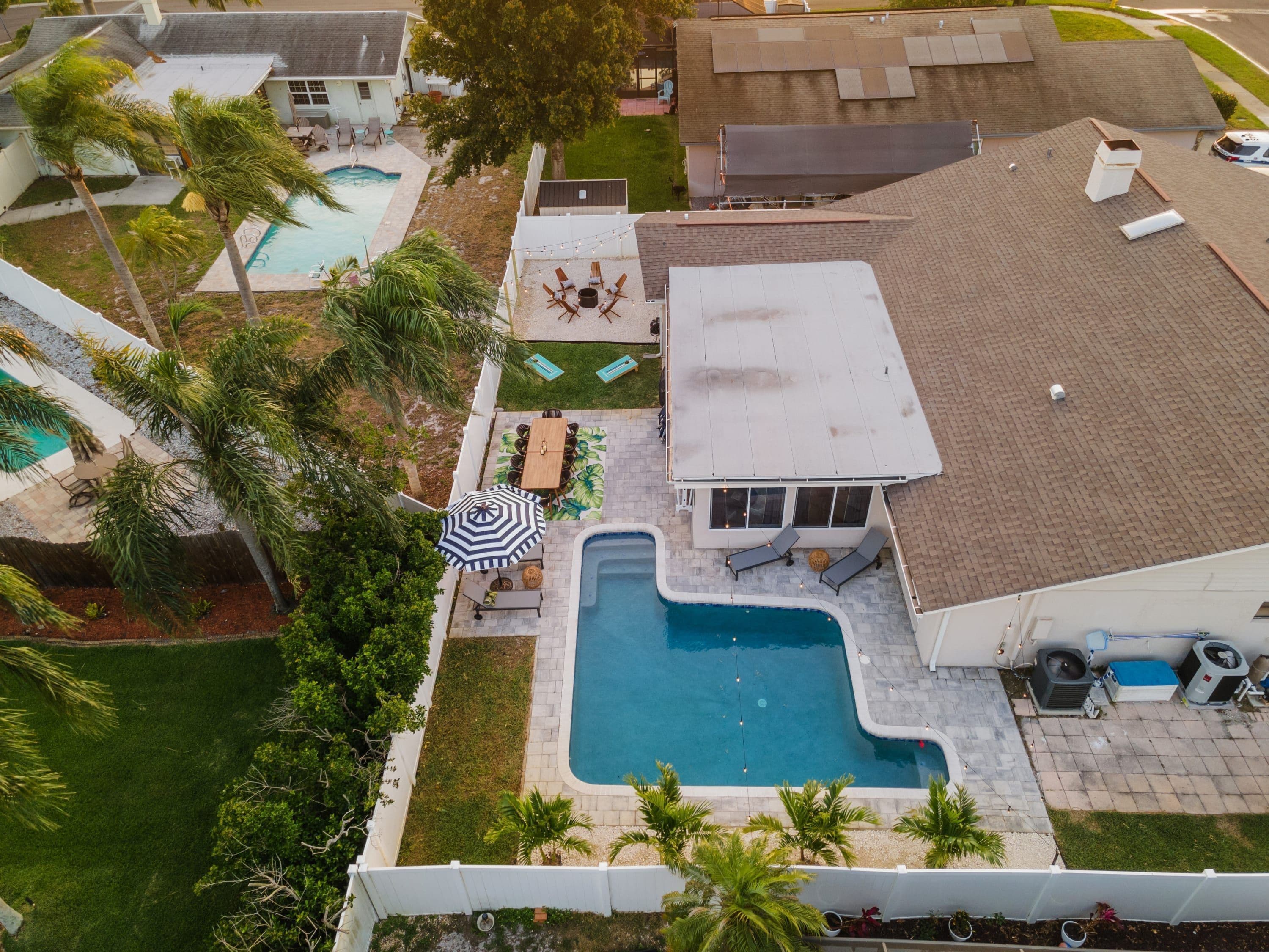 A residential property with a swimming pool, outdoor seating area, and a covered patio.