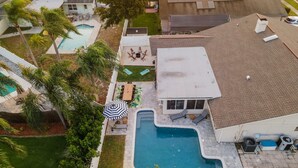 A residential property with a swimming pool, outdoor seating area, and a covered patio. - Epic Yard Movie Theater Pool Arcade Games (Seminole)