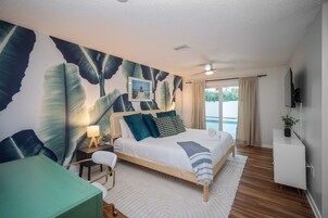 Habitación de hotel con cama, escritorio, silla, televisión y vistas al mar.