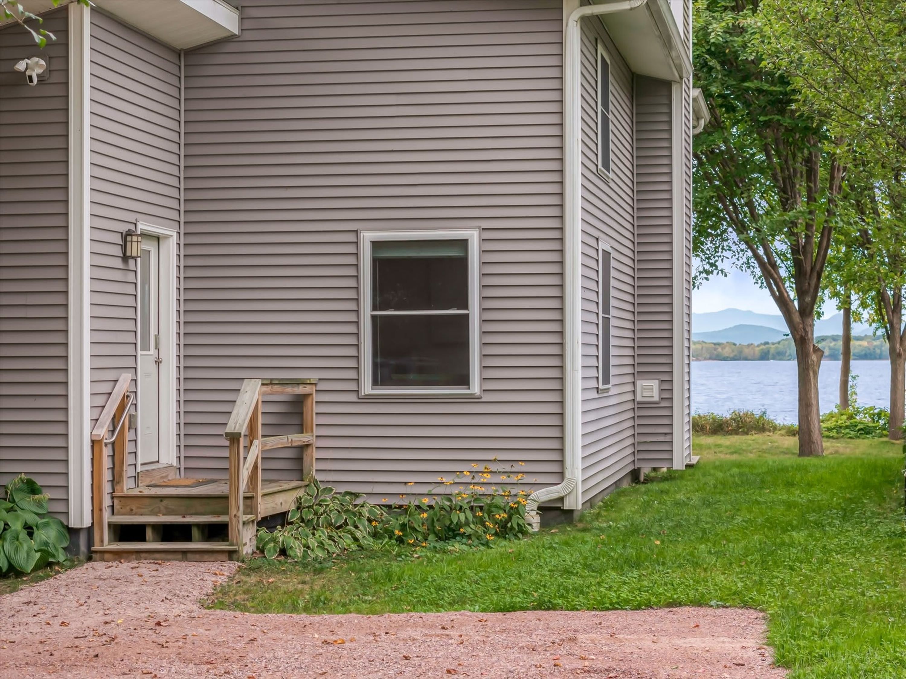 Une maison avec un porche à l’avant, une fenêtre et une vue sur un lac.