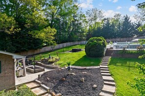 Ein angelegter Garten mit Terrasse, einem gepflegten Rasen und verschiedenen Pflanzen.