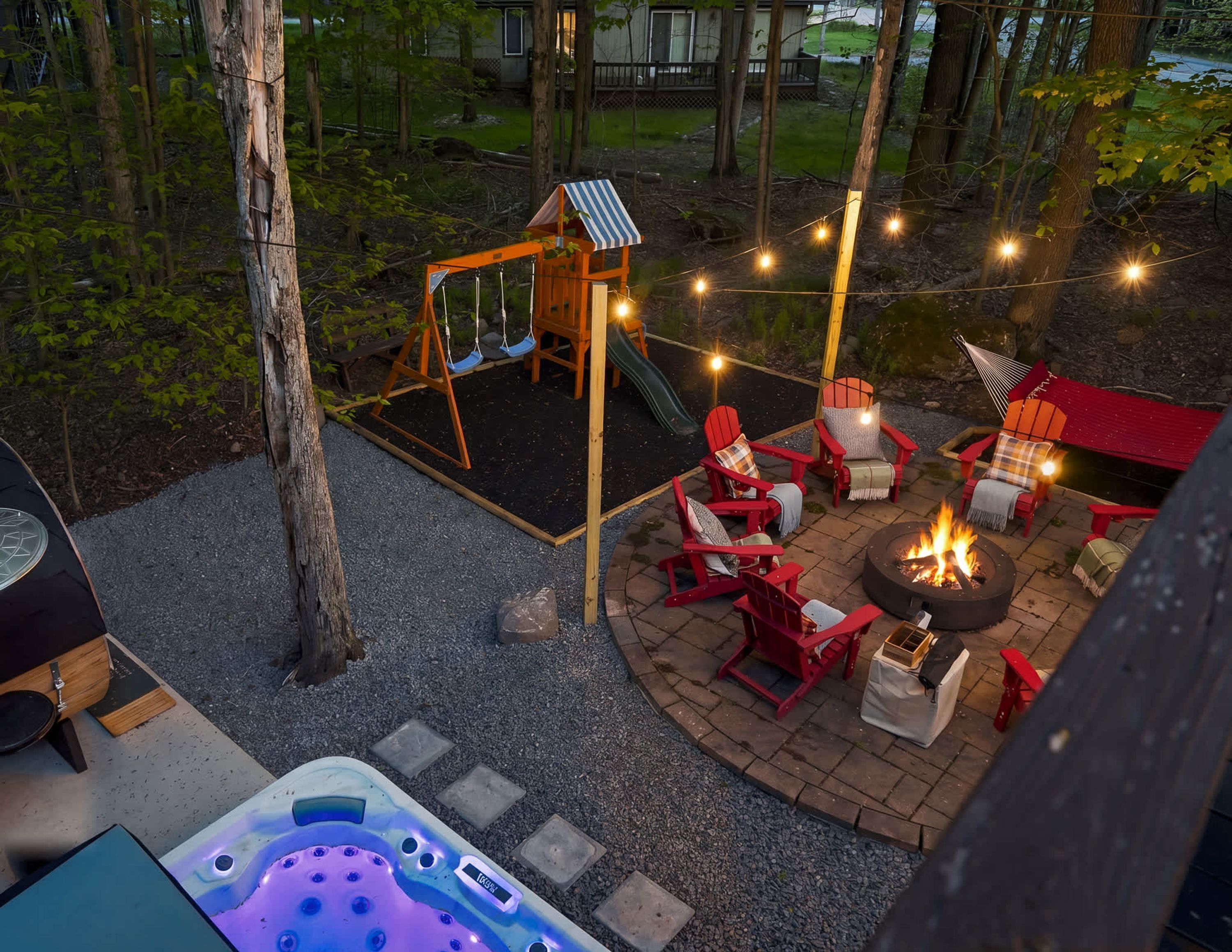 A backyard with a hot tub, outdoor seating area with Adirondack chairs, a swing set, and a fire pit.