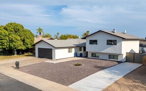 Ein zweigeschossiges Wohnhaus mit Garage, Auffahrt und einem angelegten Vorgarten.