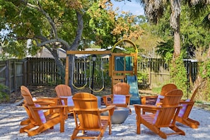 A wooden outdoor seating area with Adirondack chairs and a swing set. - Outdoor Movie Theatre Pool Putt Putt Hot Tub (Largo)