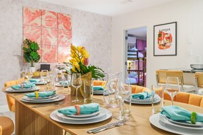 A dining area with a long table set for a meal, featuring plates, glasses, and cutlery. - Outdoor Movie Theatre Pool Putt Putt Hot Tub (Largo)