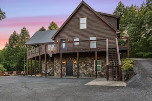 A two-story log cabin with a stone facade, a balcony, and a basketball hoop. - Mountain Views Hot Tub Pool Table Firepit Games (Epworth)