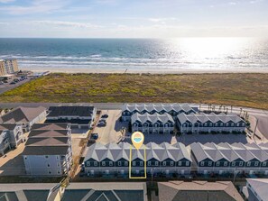 A coastal residential area with a row of houses, a parking lot, and a beach in the background. - Walk to Beach Private Hot Tub Pool Dog Friendly (Corpus Christi)