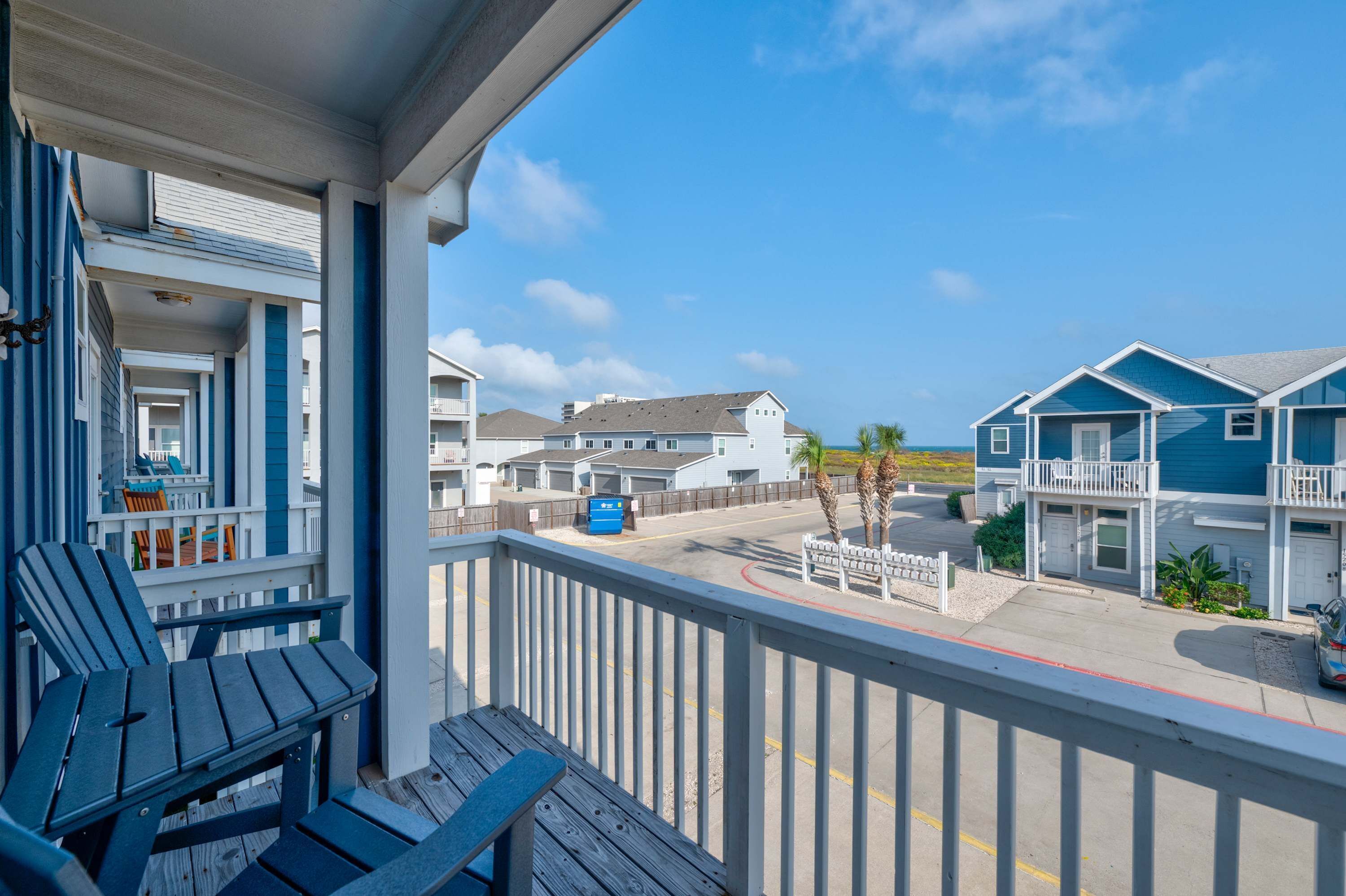 A beachfront property with a balcony, outdoor seating, and a view of the ocean.