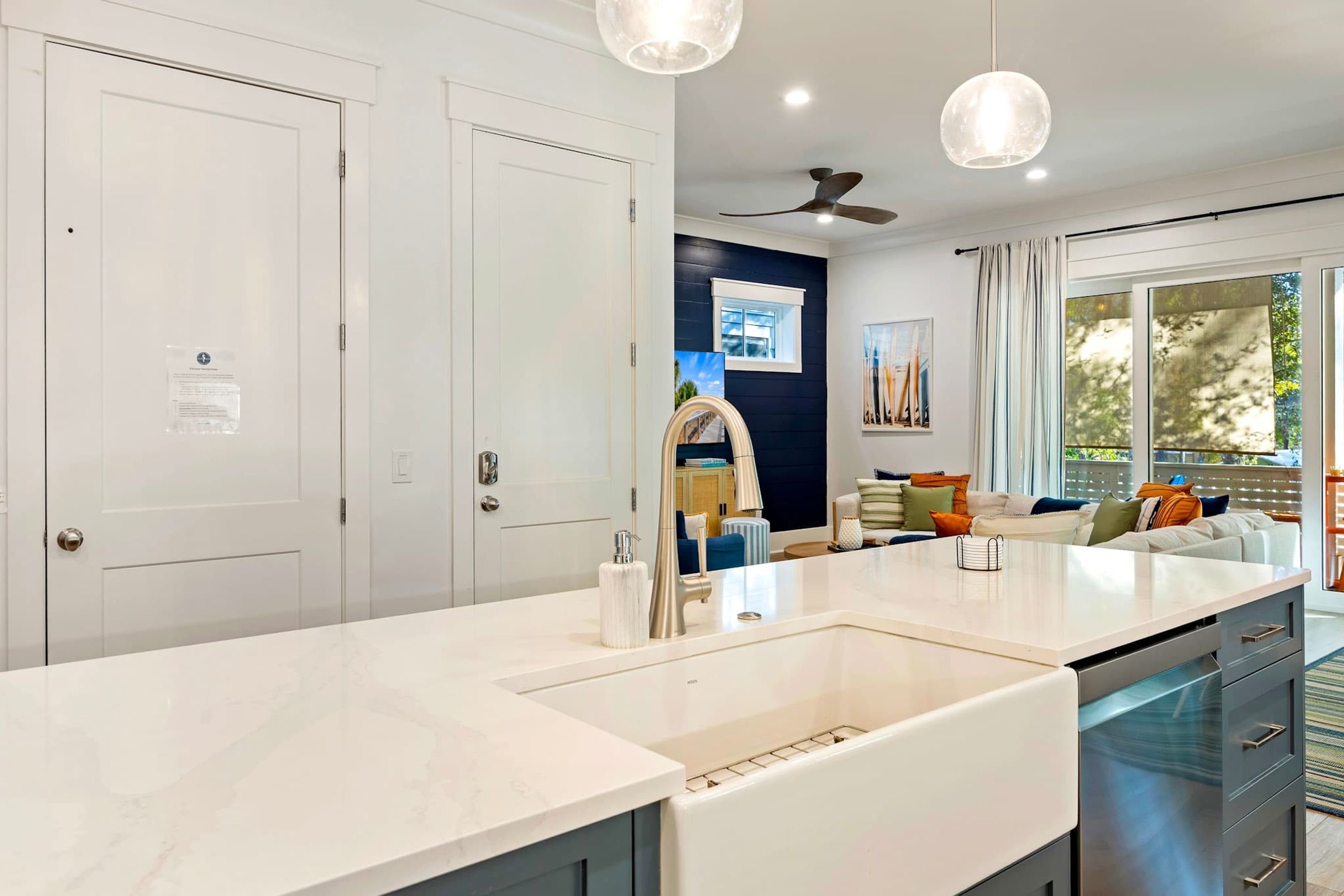 A modern kitchen with a white countertop, a built-in oven, and a ceiling fan.