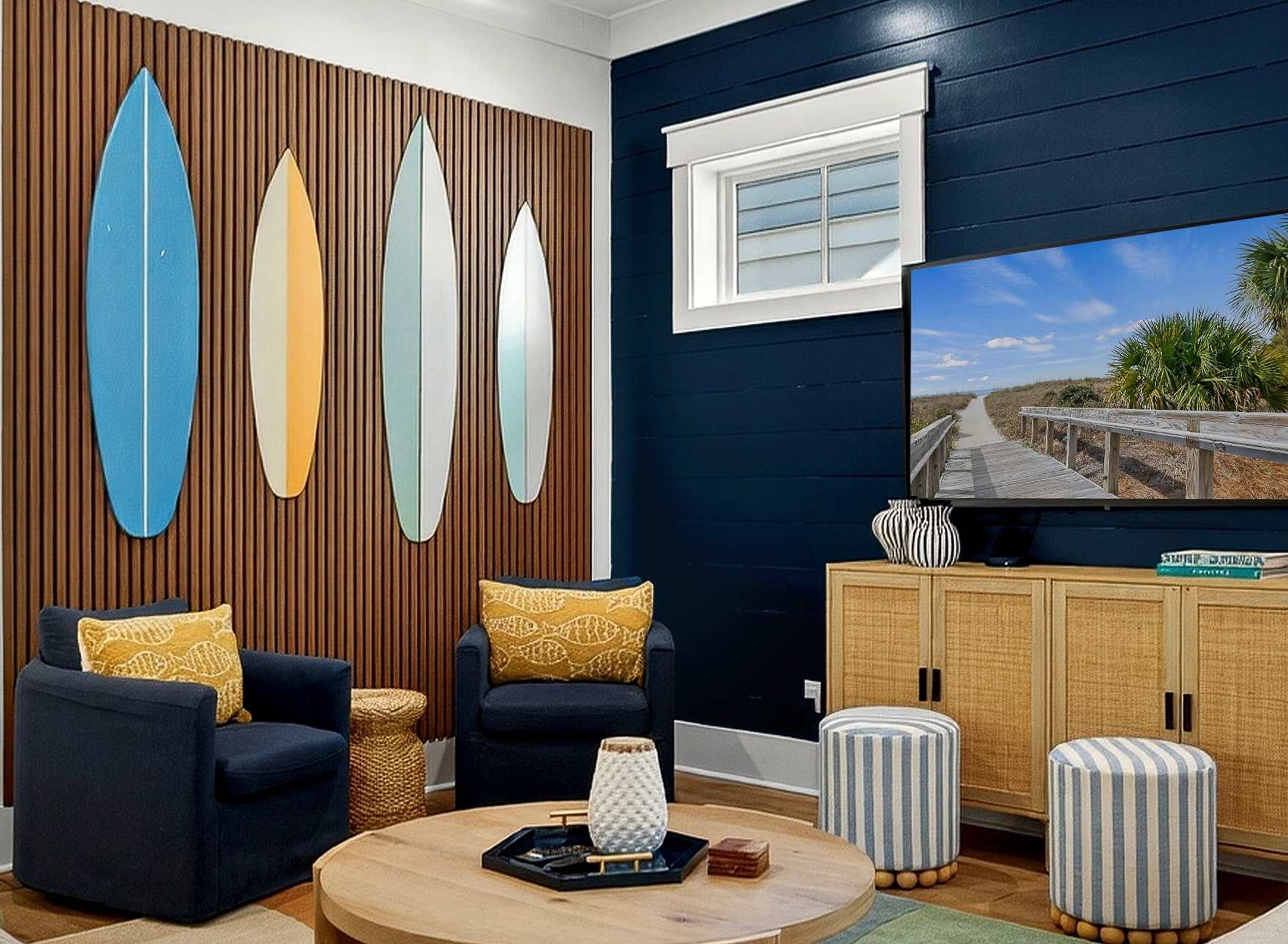 A living room with a TV, two sofas, a coffee table, and a wall with surfboard decorations.