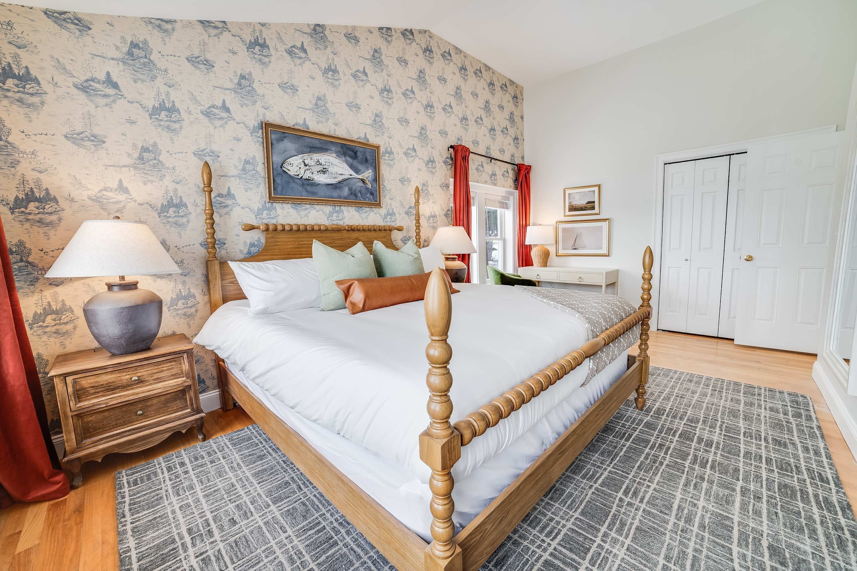 Une chambre à coucher avec un lit à baldaquin, une table de chevet, une lampe, une commode et une porte.