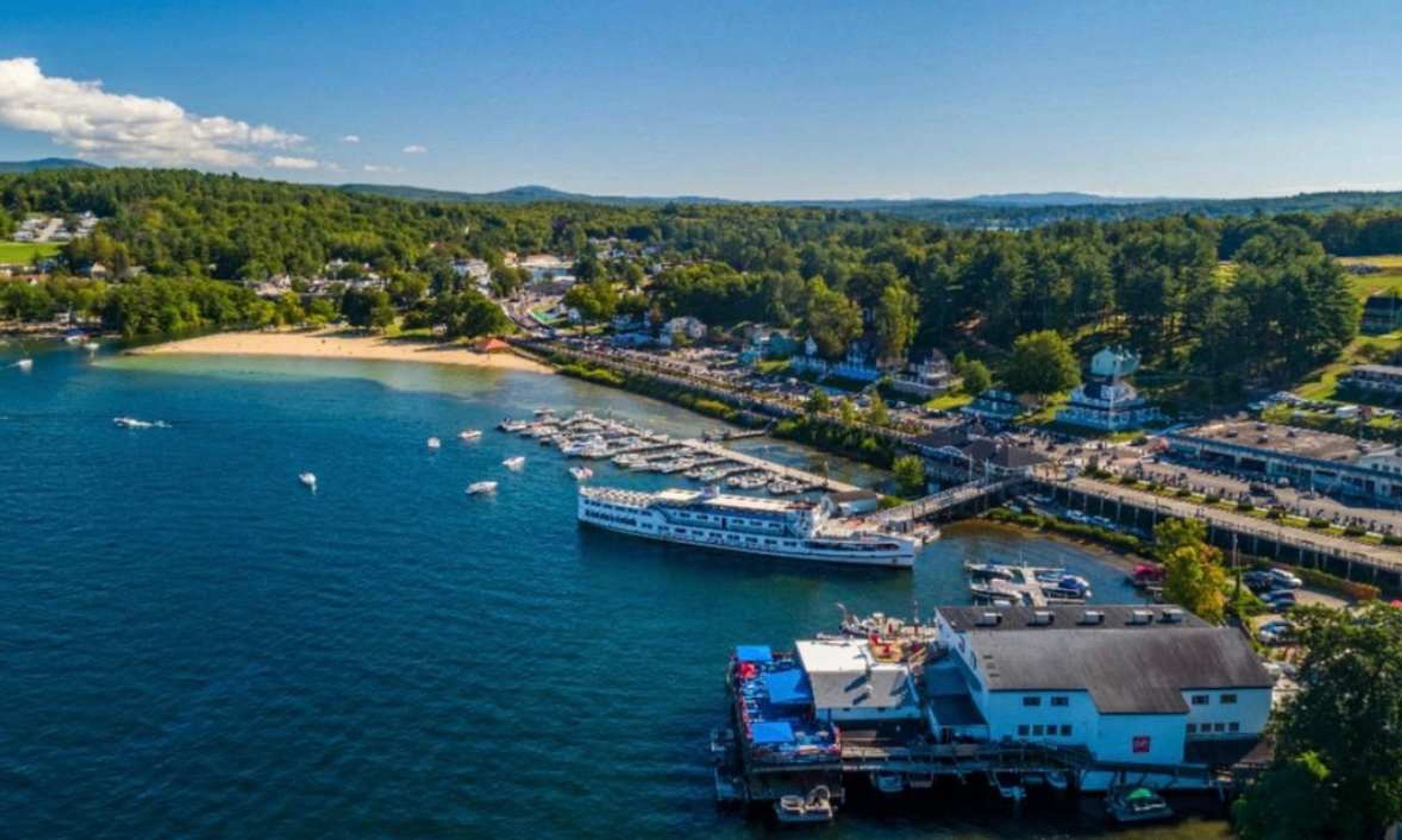 A coastal town with a large river, a bridge, and a dock with boats.