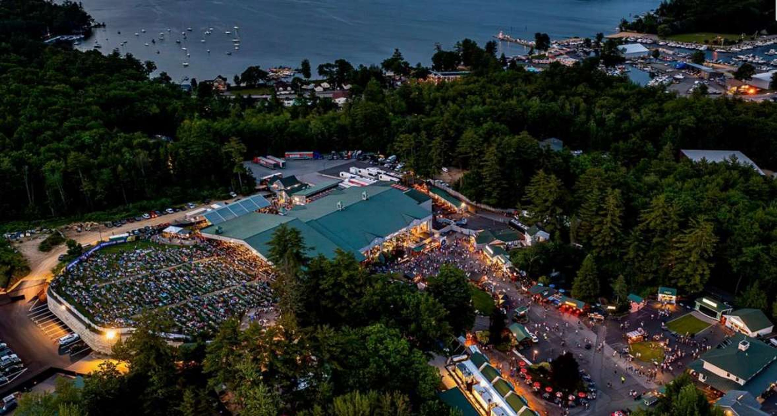 An aerial view of a large outdoor event with multiple tents and a crowd.