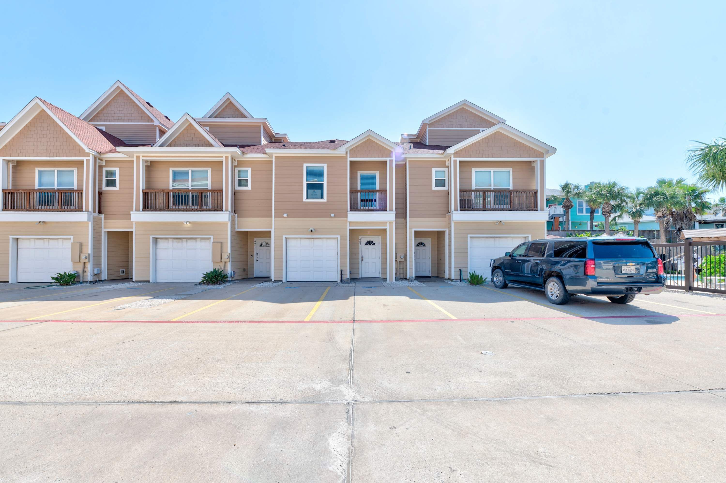 A multi-story residential building with a parking lot in front.