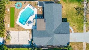 Ein Luftbild eines Anwesens mit Schwimmbad, Tennisplatz und überdachter Terrasse.