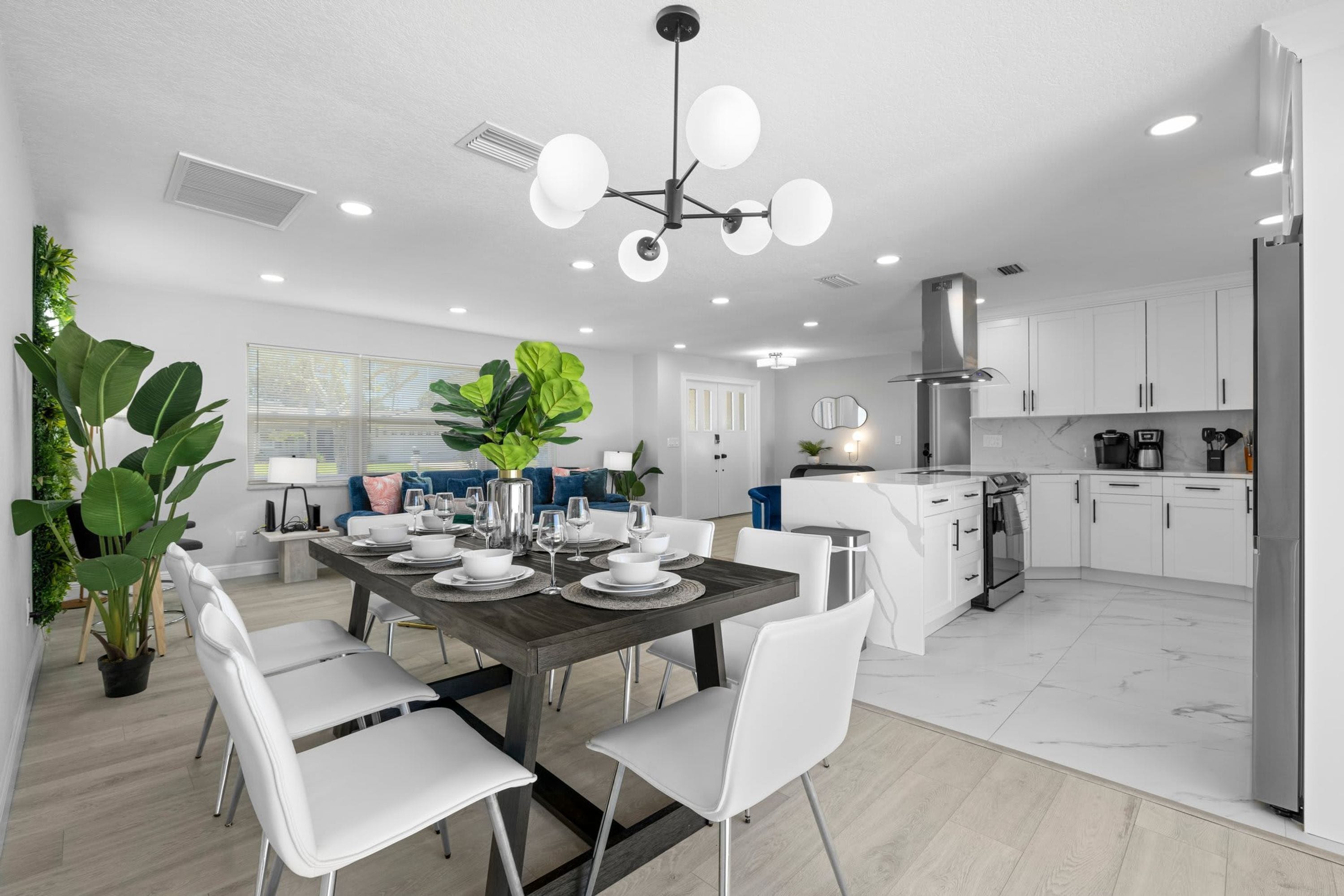 A modern kitchen with white cabinets, a stainless steel range hood, and a built-in oven.