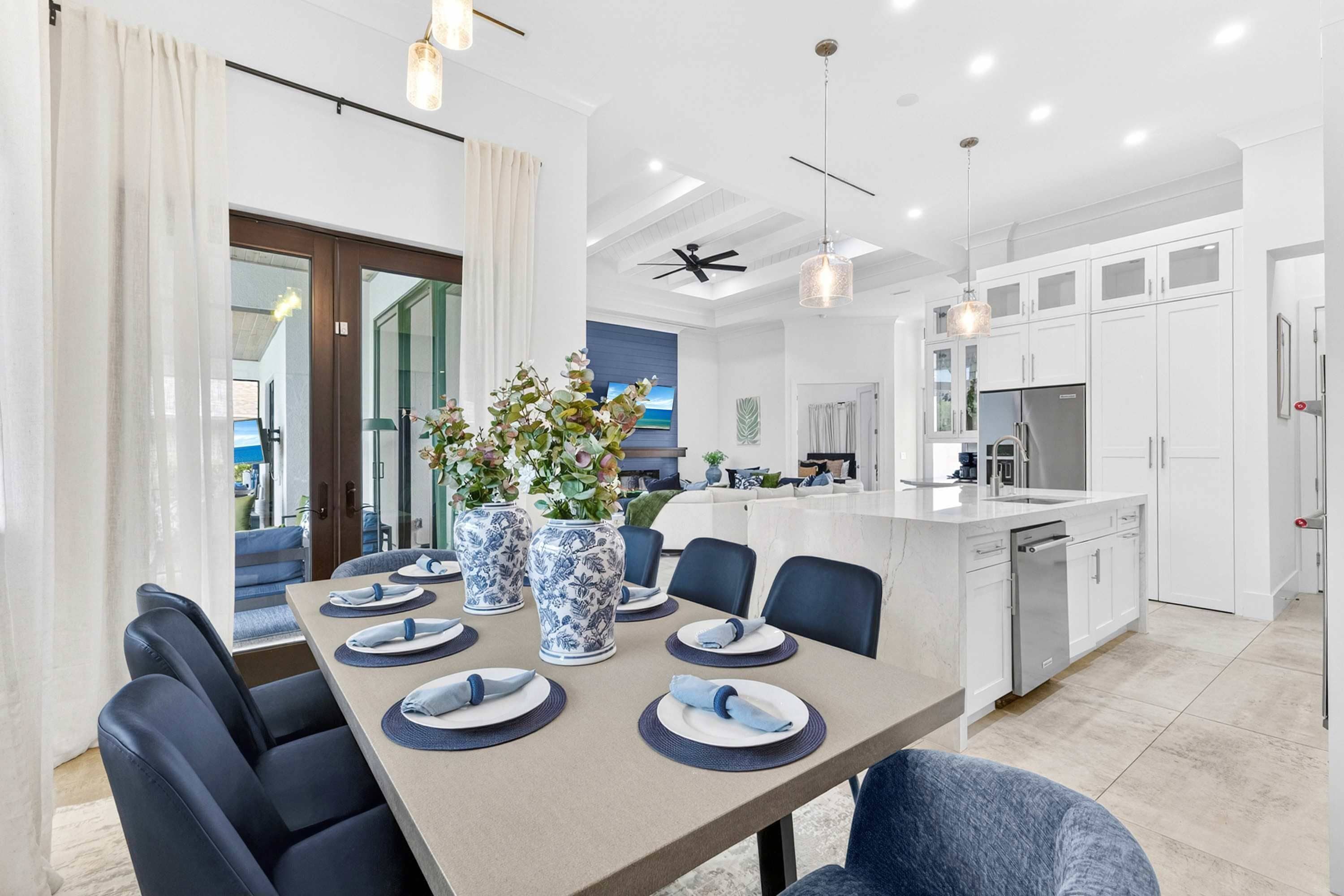 A modern kitchen with white cabinets, a built-in dishwasher, and a large island with a sink.