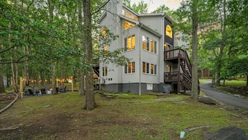 A multi-story building with a deck and a staircase leading to a second level.
