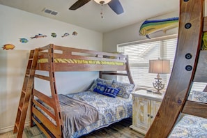 A bunk bed room with a ceiling fan, a nightstand with a lamp, and wall decals of fish. - Buena Vista- Ocean View Large Pool Boardwalk (Port Aransas)