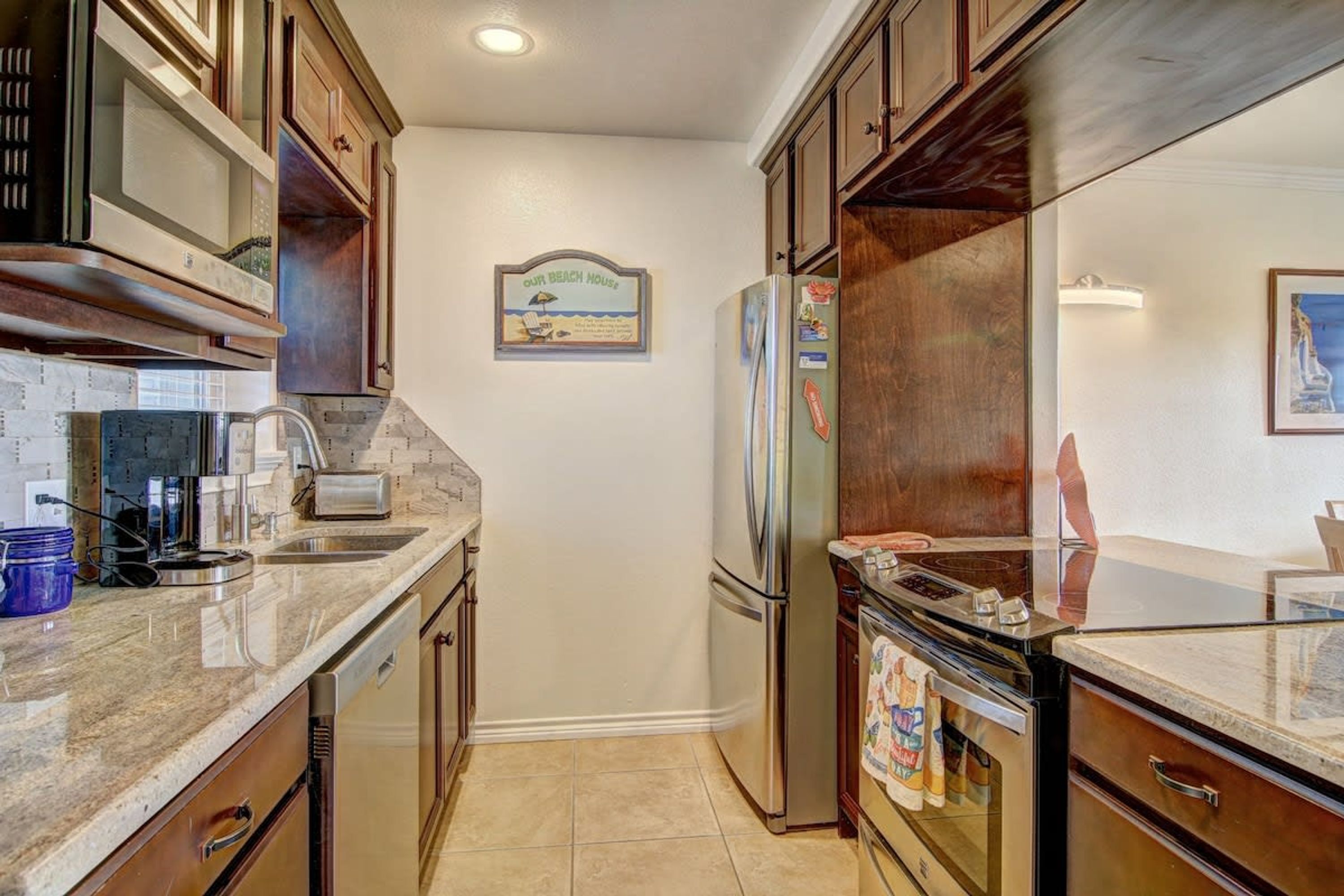 A compact kitchen with a built-in oven, a refrigerator, and a coffee maker.
