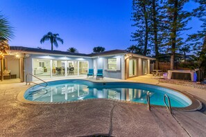 A residential property with a swimming pool, outdoor seating, and a covered patio area. - Sleeps 8 Tiki Bar Pool Hot Tub Fire Pit (Tampa)