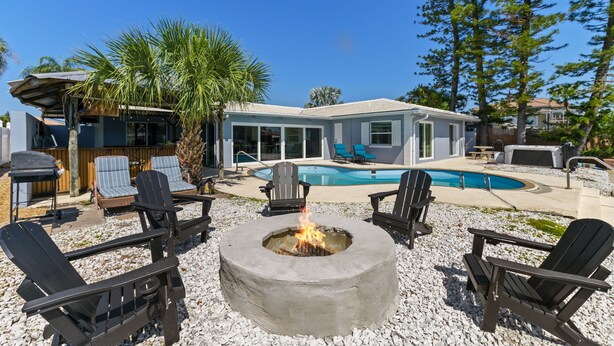 A backyard with a fire pit, outdoor seating, a swimming pool, and a house. - Sleeps 8 Tiki Bar Pool Hot Tub Fire Pit (Tampa)