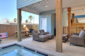 A poolside area with a hot tub, lounge chairs, and a wooden deck. - Highway 9 Private Pool BBQ (Port Aransas)