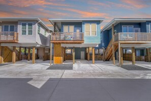 A row of beach houses with wooden decks and a clear sky. - Highway 9 Private Pool BBQ (Port Aransas)