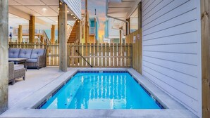 A pool area with a wooden deck, a covered seating area, and a view of the sky. - Highway 9 Private Pool BBQ (Port Aransas)