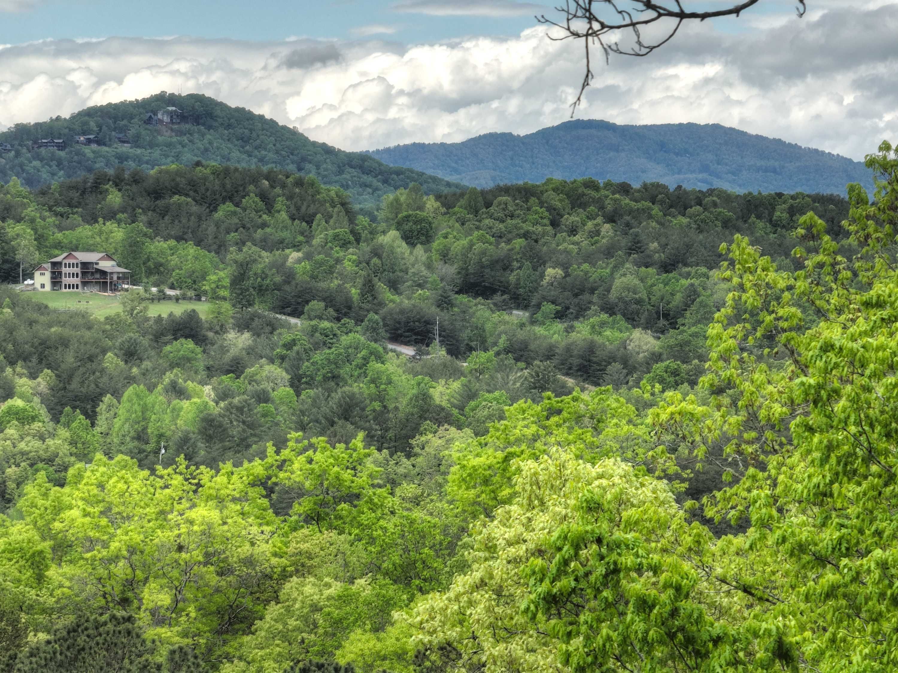 Uma casa rodeada por floresta densa e montanhas.