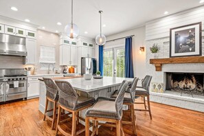 A modern kitchen with stainless steel appliances, a central island with bar stools, and a fireplace. - 10 Mins to Mercedes-benz Stadium Dog Friendly (Atlanta)