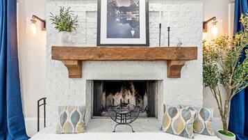 A fireplace with a white brick surround, a wooden mantel, and a framed picture above.