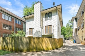 A residential street with houses, a wooden fence, and a clear sky. - 10 Mins to Mercedes-benz Stadium Dog Friendly (Atlanta)
