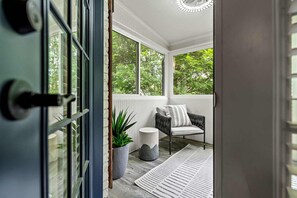 A porch with a chair, a potted plant, and a rug. - 10 Mins to Mercedes-benz Stadium Dog Friendly (Atlanta)