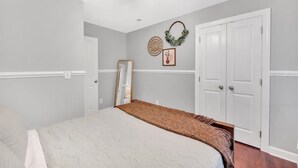 A bedroom with a bed, a wardrobe, a mirror, and wall decorations. - Lakefront Villa Hot Tub Game Room Boat Lift (Mooresville)