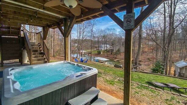 A hot tub under a wooden gazebo with a view of a lake and houses in the background. - Lakefront Villa Hot Tub Game Room Boat Lift (Mooresville)