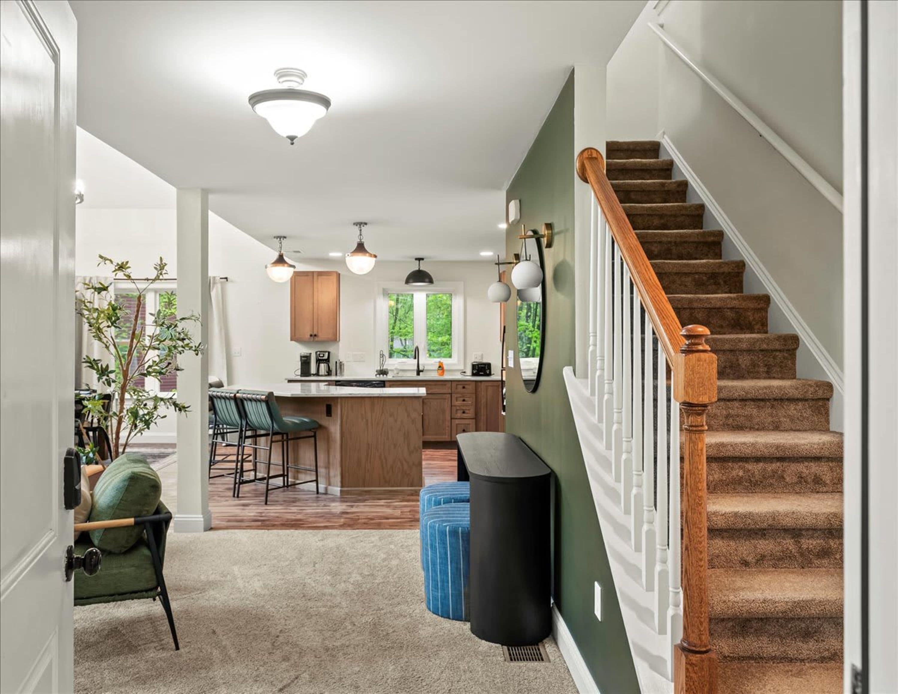 A kitchen with a central island, wooden cabinets, and pendant lighting.