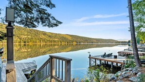 A wooden dock extending into a calm lake with a forested hillside in the background. - Luxury Lakefront 5 Br Home Hot Tub Arcade (Truckee)