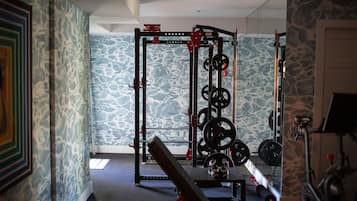 A gym with a squat rack, benches, and a stationary bike.
