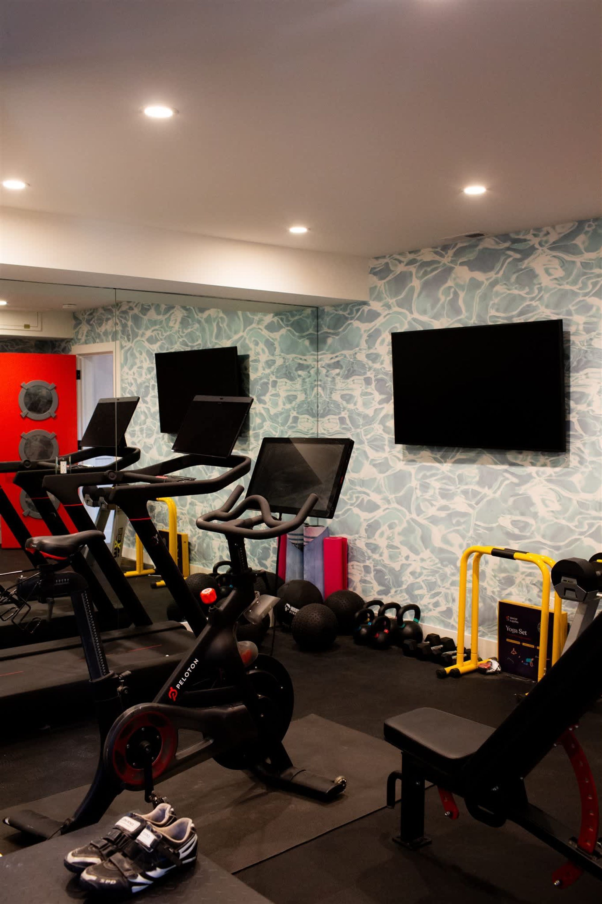 Uma academia com bicicletas ergométricas, esteiras e equipamentos de musculação.