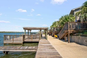A wooden dock leading to a covered area with a view of the water. - Scoop Deck Dock Pool Balcony Views (Corpus Christi)