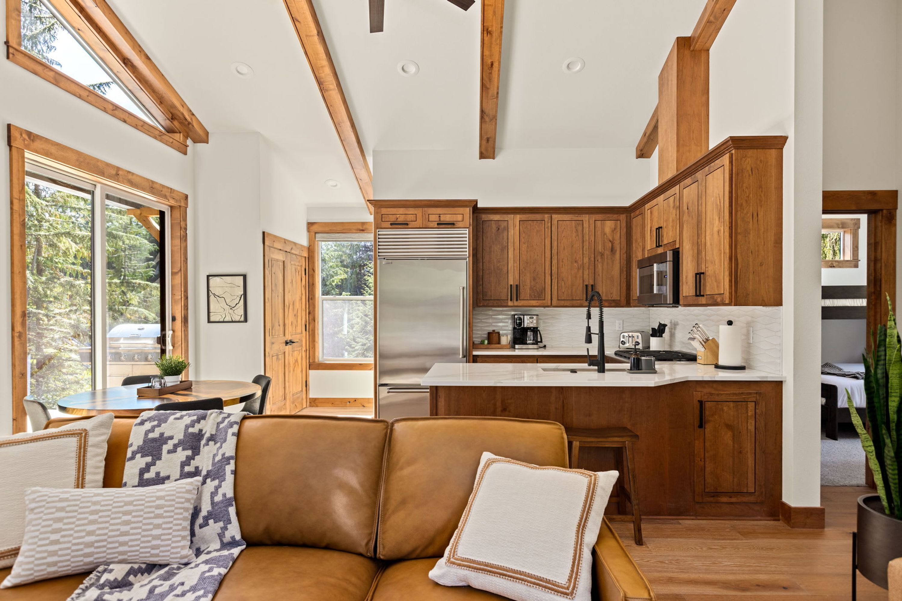 A modern kitchen with wooden cabinets, stainless steel appliances, and a central island.
