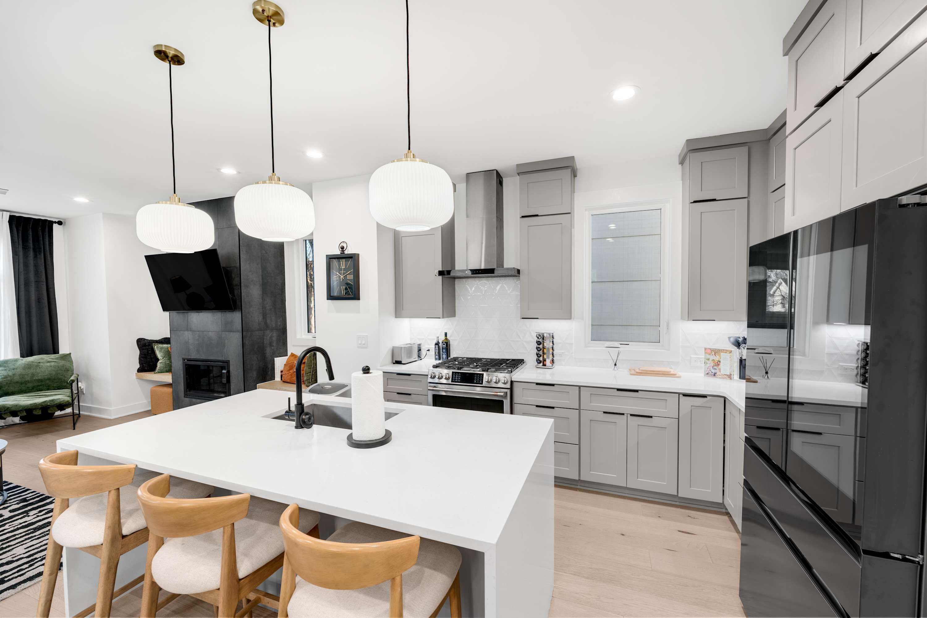 A modern kitchen with a central island, stainless steel appliances, and pendant lighting.