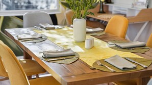 A dining table set with yellow placemats, folded napkins, and silverware. - Poolside Retreat Sleeps 8 Putt Putt Hot Tub (Bradenton)
